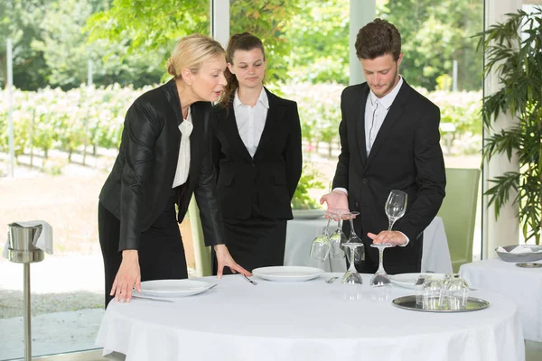 Estudantes que montam uma mesa de restaurante — Fotografia de Stock