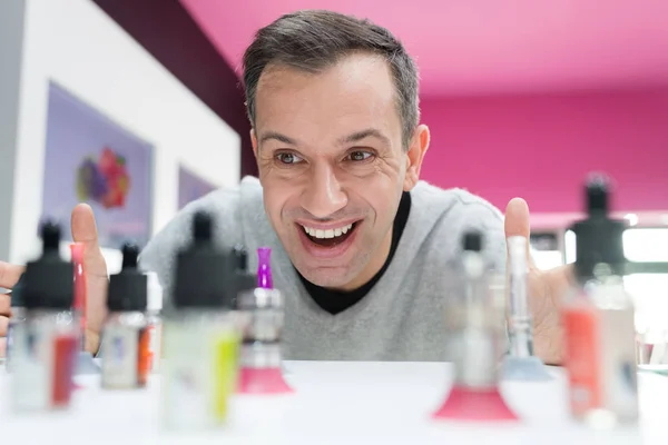 Happy man looking at electronic cigarettes in store — Stock Photo, Image