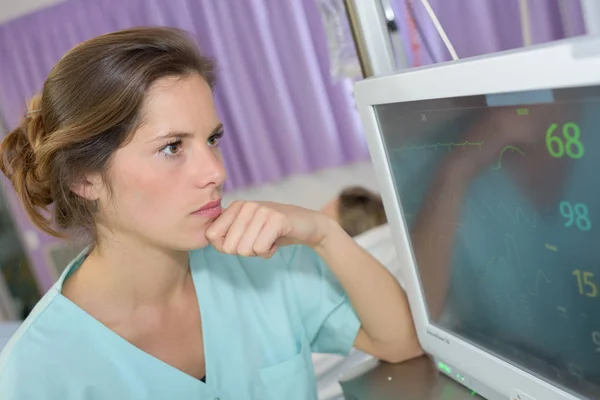 Vacker kvinnlig sjuksköterska kontrollera skärmen — Stockfoto
