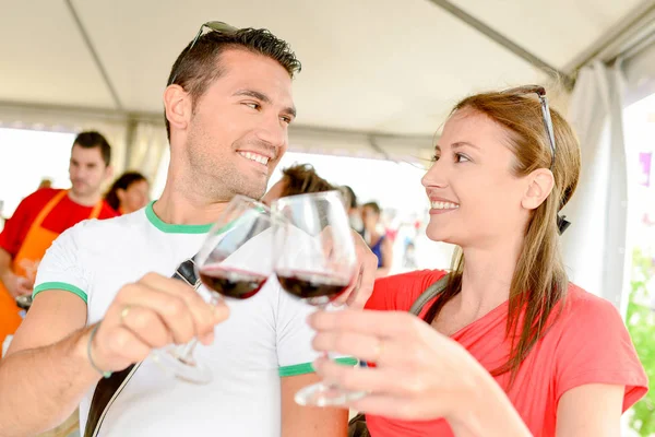 Paar stößt mit Rotwein an — Stockfoto