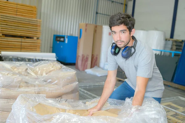 Ο άνθρωπος αποσφράγισης της συσκευασίας πλαστικό από παλέτα των Τσάντες — Φωτογραφία Αρχείου
