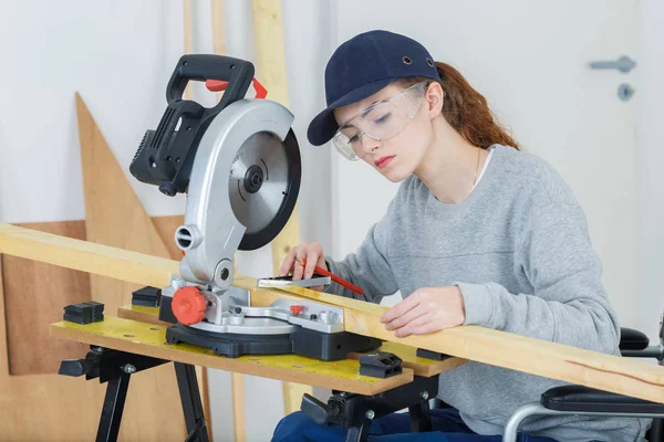 Mladí Latinské ženské carpenter měření a značení dřeva — Stock fotografie