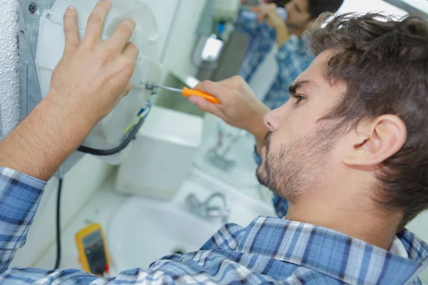 Comerciante fixação problema elétrico com secador de mão — Fotografia de Stock