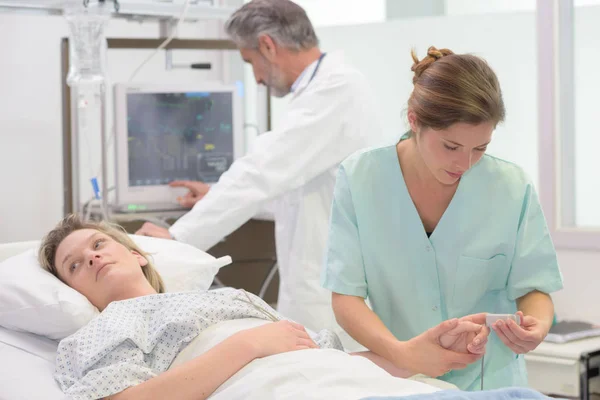 Arts en verpleegkundige met vrouwelijke patiënt — Stockfoto