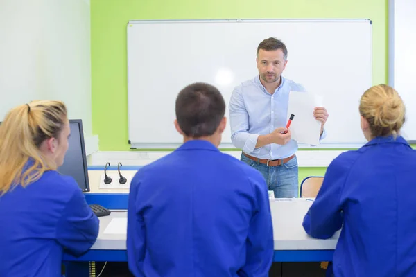 Lärare hålla pappret mot klass — Stockfoto