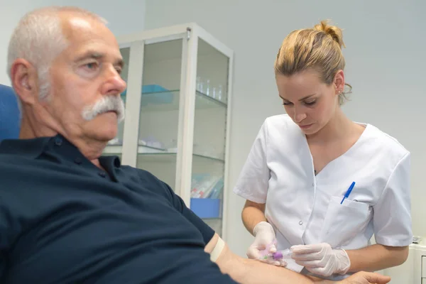 Krankenschwester entnimmt einem Patienten Blut — Stockfoto