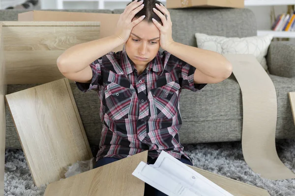 Mujer exasperada tratando de montar muebles — Foto de Stock