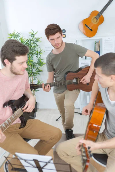 Gruppo di amici che suonano la chitarra a casa — Foto Stock