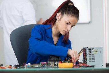 young female tests electronic equipment in service centre clipart
