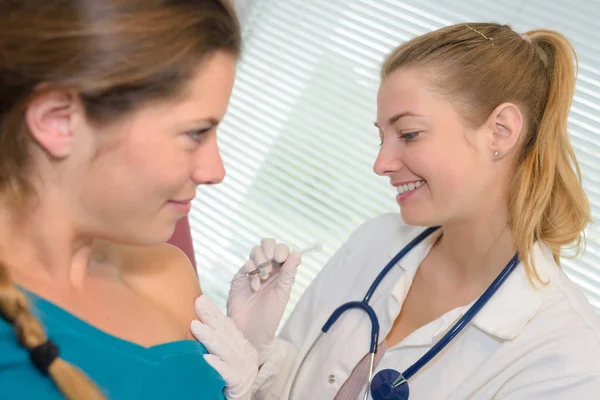 Friendly female doctor touching patient shoulder — Stock Photo, Image