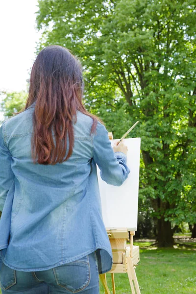 Young woman artist painting in the park — Stock Photo, Image