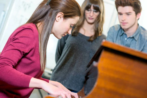 Leende unga kvinnliga kunden att välja synthesizer i butik — Stockfoto