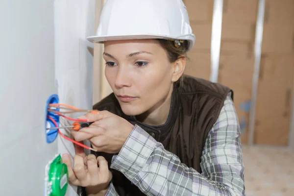 Elettricista femmina che ispeziona i fili — Foto Stock