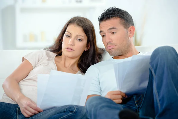 Jovem casal preocupado discutindo sobre contas em casa — Fotografia de Stock