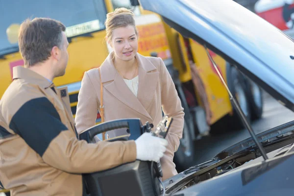 Junger Mechaniker erklärt Kundin in Garage Probleme — Stockfoto