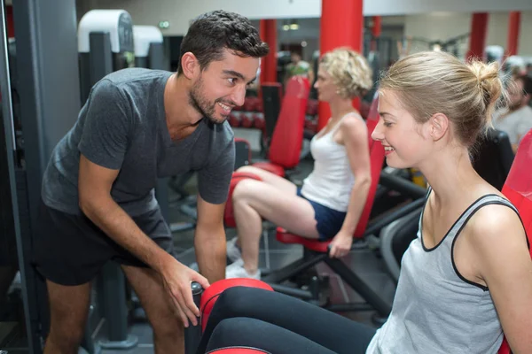 Jonge volwassen vrouw uit te werken met personal trainer — Stockfoto