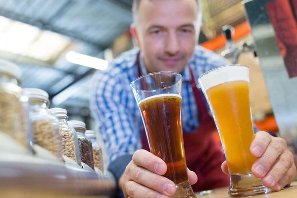 Cervecero en uniforme degustación de cerveza en la cervecería —  Fotos de Stock