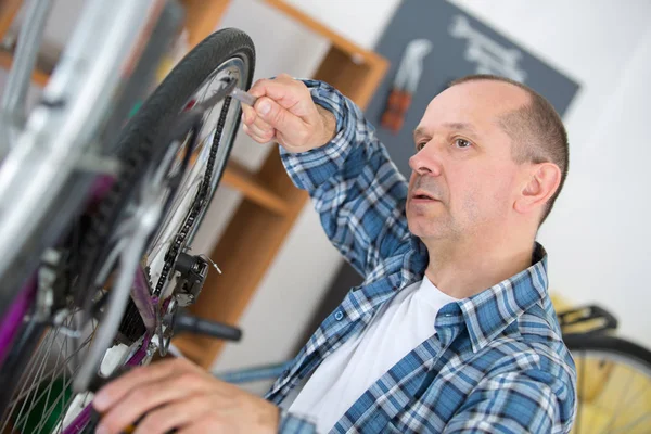 Adam bisikleti tamir ediyor. — Stok fotoğraf
