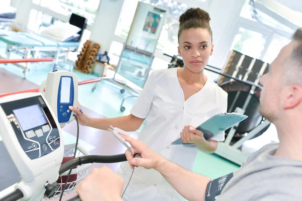 Female physiotherapist monitoring patients rehabilitation — Stock Photo, Image