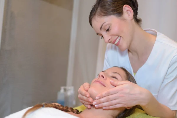 Jovem mulher tendo massagem facial no spa — Fotografia de Stock