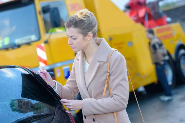 Mujer llenando papeles de remolque de coche — Foto de Stock