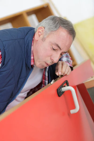 Man fixing the door with screwdriver — Stock Photo, Image