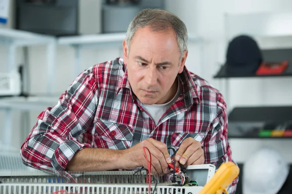 Technician testing heater with multimeter — Stock Photo, Image