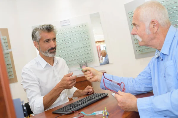 Optiker und Augenarzt, um dem Patienten in die Augen zu sehen — Stockfoto
