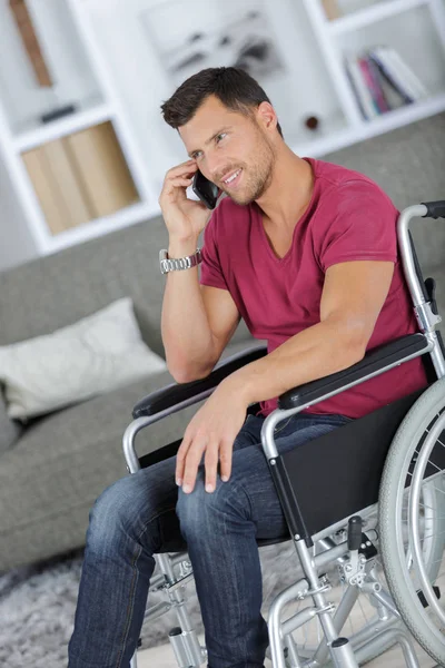 Man in de rolstoel belt op de mobiele telefoon — Stockfoto