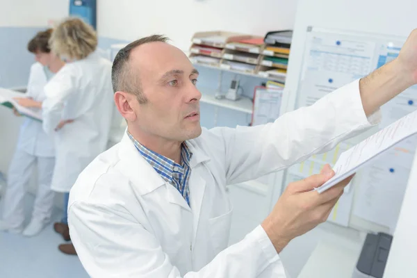 Trabajador de laboratorio que presenta el papeleo — Foto de Stock