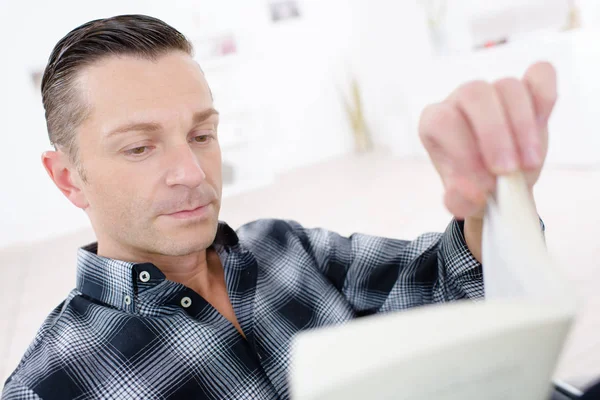 Homme lisant un livre dans sa chambre — Photo