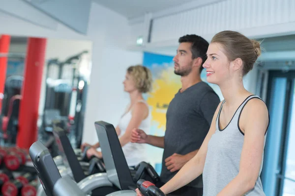 Spor salonunda egzersiz makineleri kullanan kişiler — Stok fotoğraf