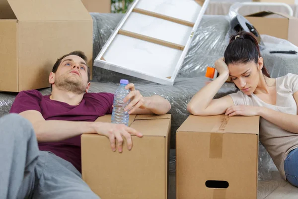 Couple fatigué avec des boîtes déménageant dans un nouvel appartement à la maison — Photo