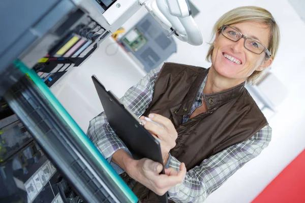 Técnico feminino que fixa uma impressora — Fotografia de Stock