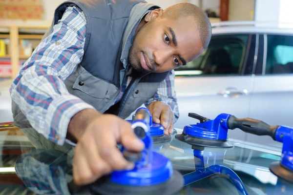 car mechanic replacing window