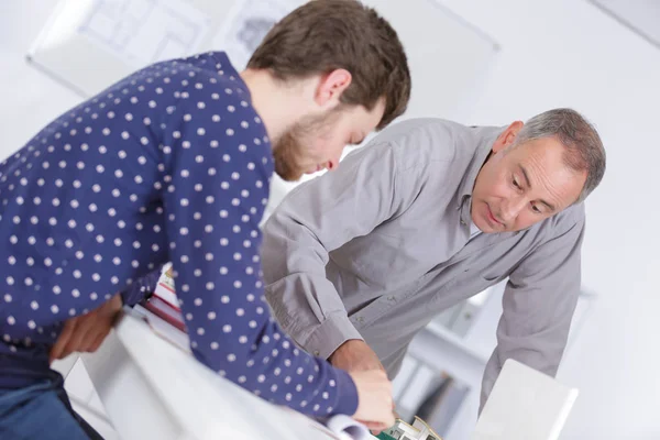 Profesor ayudando a estudiante mostrándole cómo hacer — Foto de Stock