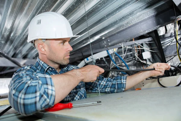 Electricista masculino en escalera instalando luz en el techo —  Fotos de Stock