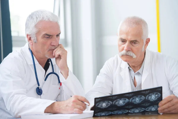 Médicos ancianos infelices mirando la foto de rayos X — Foto de Stock