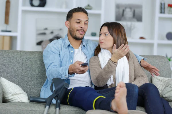 Namorado ferido assistindo tv com namorada — Fotografia de Stock