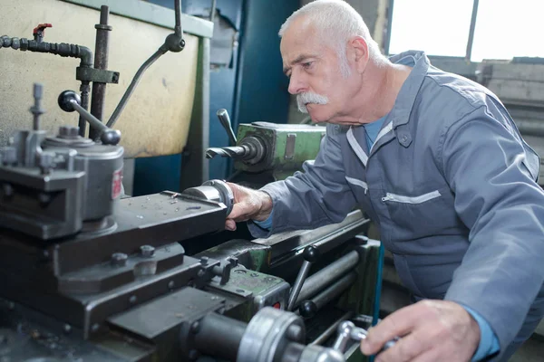 Senior mannelijke timmerman snijden hout op bouwplaats — Stockfoto