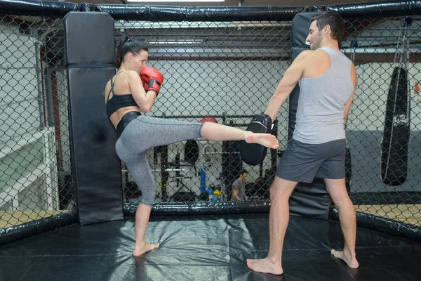 Koçuyla kickboks antrenmanı yapan genç bir kadın. — Stok fotoğraf