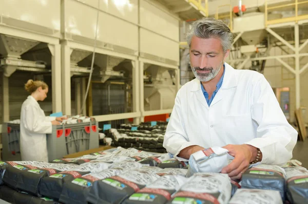 Man inspekterar paketen i fabriken — Stockfoto