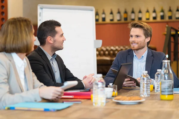 Affärsmän i formalwear diskuterar något under affärslunch — Stockfoto