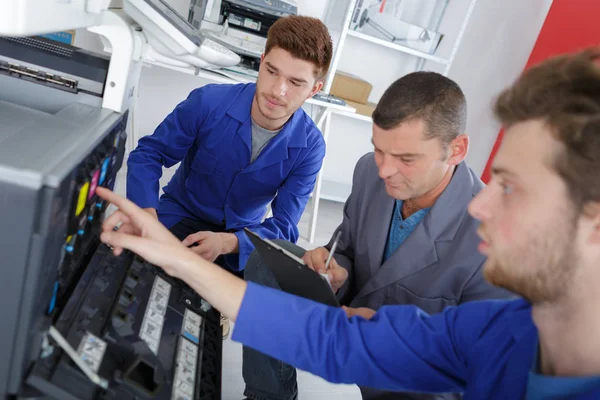 Groep van leerling mending een printer — Stockfoto