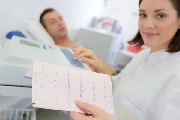 Femme regardant l'impression du moniteur cardiaque — Photo