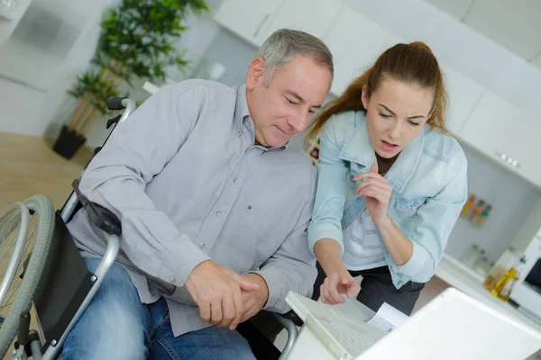 Foto av glad äldre man med funktionshinder och bra sjuksköterska — Stockfoto