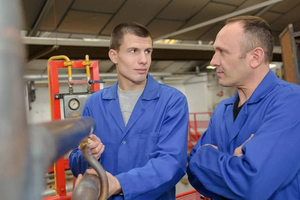 Mannen stonden door machines in de fabriek — Stockfoto