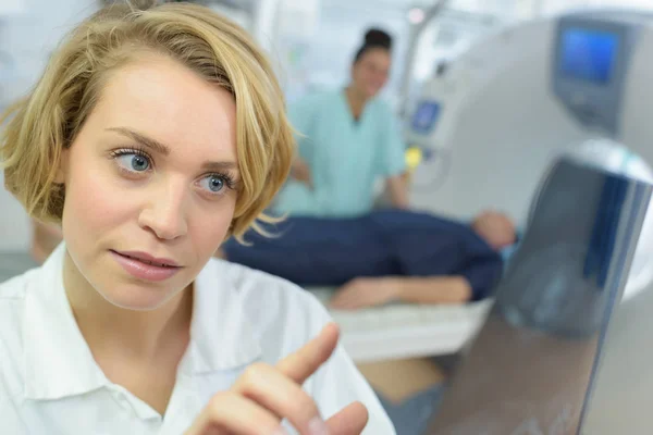 Personale medico che consulta le radiografie nella sala scanner — Foto Stock