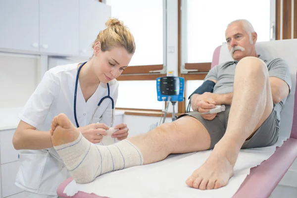 Arzt verband Senioren Bein im Krankenhaus — Stockfoto