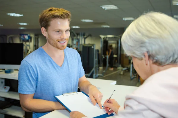 Entraîneur de fitness offrant stylo pour signer le contrat de gymnase — Photo